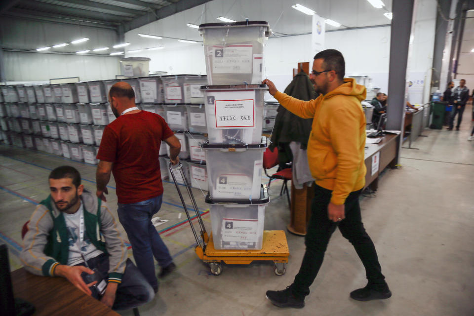 Workers carry ballot boxes at Central Election Committee counting center in Fushe Kosove, Kosovo, on Monday, Oct. 7, 2019. Kosovo's opposition parties have won a snap election, overcoming the former independence fighters who have governed the country since its war 20 years ago. With 96% of the votes counted Monday the left-wing Movement for Self-Determination Party, or LVV, has 26% of the votes, one percentage point more than the conservative Democratic League of Kosovo, or LDK, also formerly in opposition. (AP Photo/Visar Kryeziu)