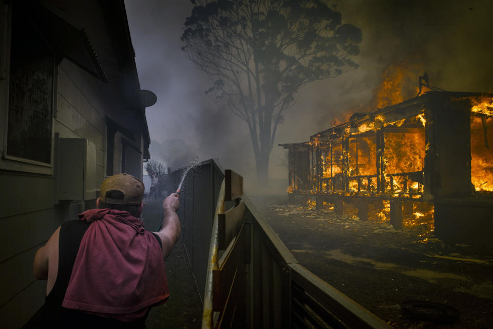 Un hombre trata de proteger su propiedad en Lake Conjola, Nueva Gales del Sur, Australia, en la víspera de Año Nuevo, el 31 de diciembre de 2019. (Matthew Abbott/The New York Times)