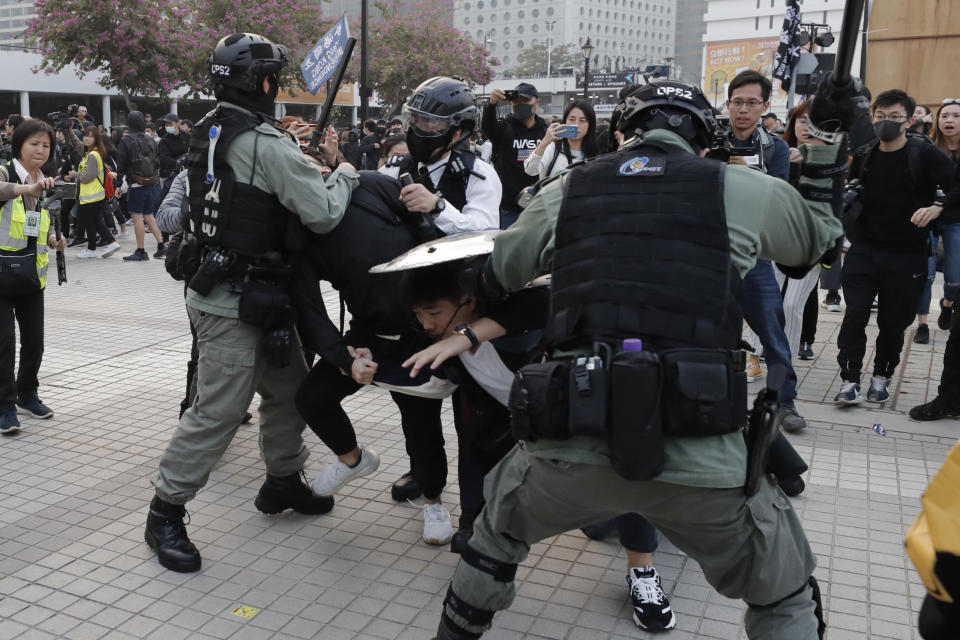 Riot policemen arrest protesters during a rally to show support for Uighurs and their fight for human rights in Hong Kong, Sunday, Dec. 22, 2019. (AP Photo/Lee Jin-man)