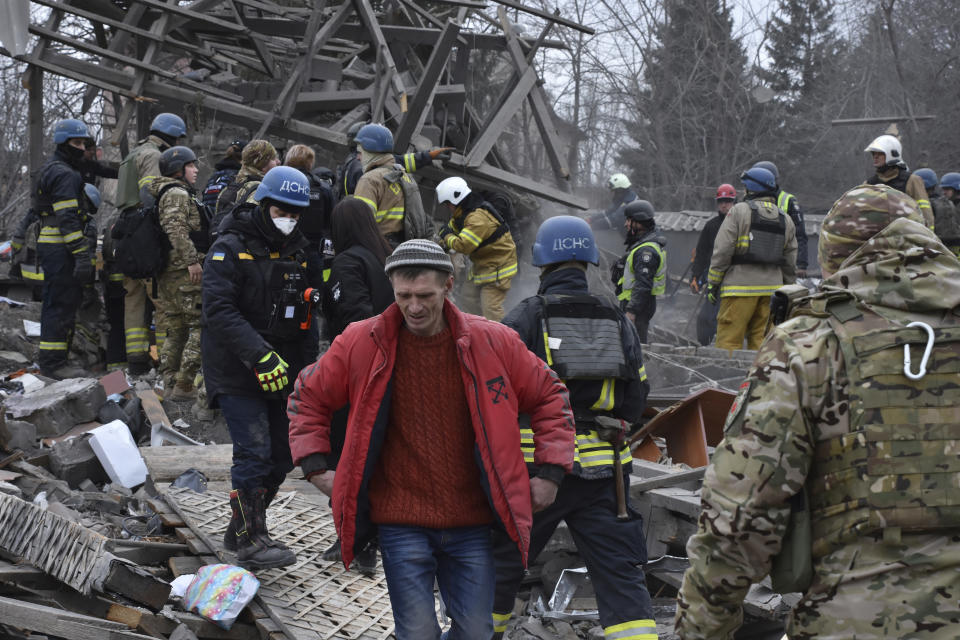 People clear the debris at the site of Russia's air attack in Zaporizhzhia, Ukraine, Friday, Dec. 29, 2023. (AP Photo/Andriy Andriyenko)