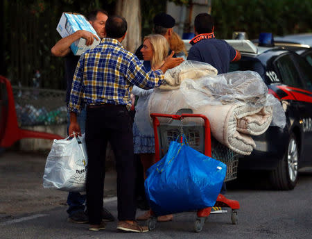 A man carries his belonging following an earthquake in Amatrice, central Italy, August 24, 2016. REUTERS/Stefano Rellandini