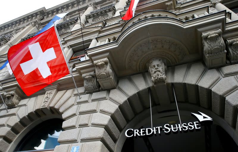 FILE PHOTO: Switzerland's national flag flies below a logo of Swiss bank Credit Suisse in Zurich