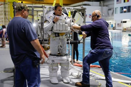 NASA Commercial Crew Astronaut Josh Cassada is helped to get into his space suit at NASA's Neutral Buoyancy Laboratory (NBL) training facility near the Johnson Space Center in Houston