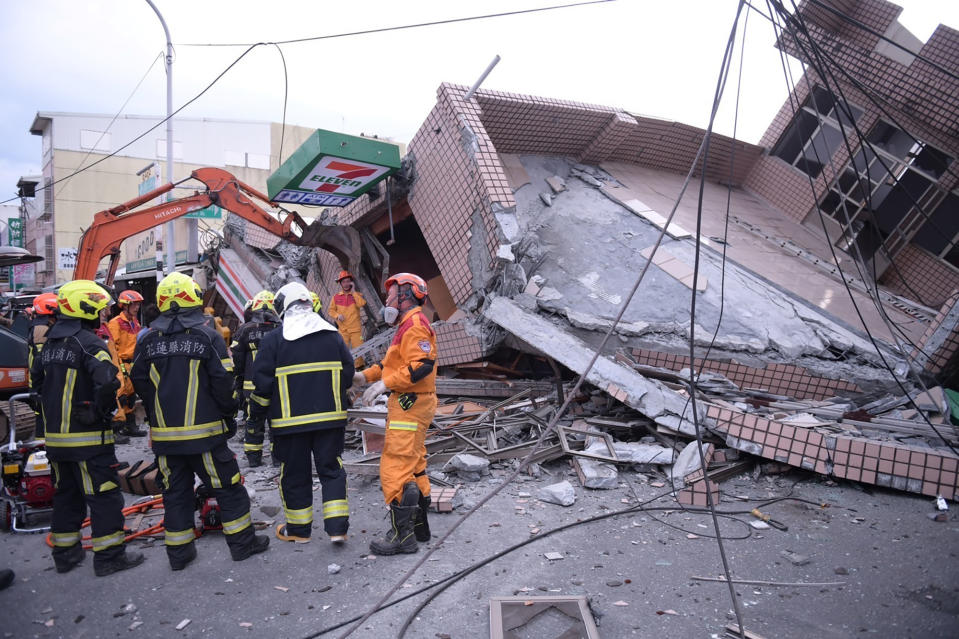 In this photo provided by Hualien City Government, firefighters are seen at a collapsed building during a rescue operation following an earthquake in Yuli township, Hualien County, eastern Taiwan, Sunday, Sept. 18, 2022. A strong earthquake shook much of Taiwan on Sunday, toppling at least one building and trapping two people inside and knocking part of a passenger train off its tracks at a station.(Hualien City Government via AP)