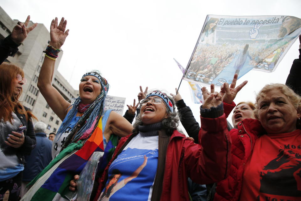 Supporters of former Argentine President Cristina Fernández shout the slogan "We will be back" outside the federal court where Fernández is on trial in Buenos Aires, Argentina, Tuesday, May 21, 2019. Fernández appeared in court Tuesday for the first in a series of corruption trials ahead of a planned run for the vice presidency. (AP Photo/Marcos Brindicci)