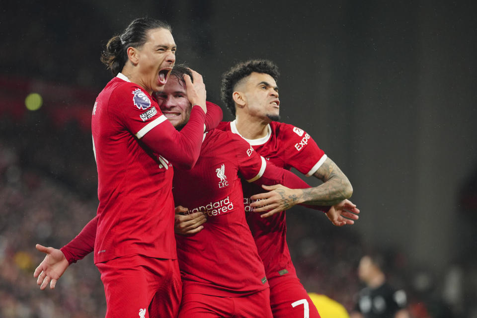 Liverpool's Alexis Mac Allister, centre, celebrates with Liverpool's Darwin Nunez, left, and Liverpool's Luis Diaz after scoring his side's second goal during the English Premier League soccer match between Liverpool and Sheffield United at the Anfield stadium in Liverpool, England, Thursday, Apr. 4, 2024. (AP Photo/Jon Super)