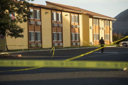 Crime scene tape criss-cross a Motel 6 parking lot where Sheriff's Deputy Danny Oliver was killed in Sacramento, California October 24, 2014. REUTERS/Noah Berger