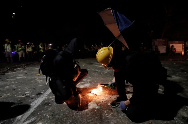 Protesters light up a molotov cocktail during a standoff with riot police at the Chinese University of Hong Kong