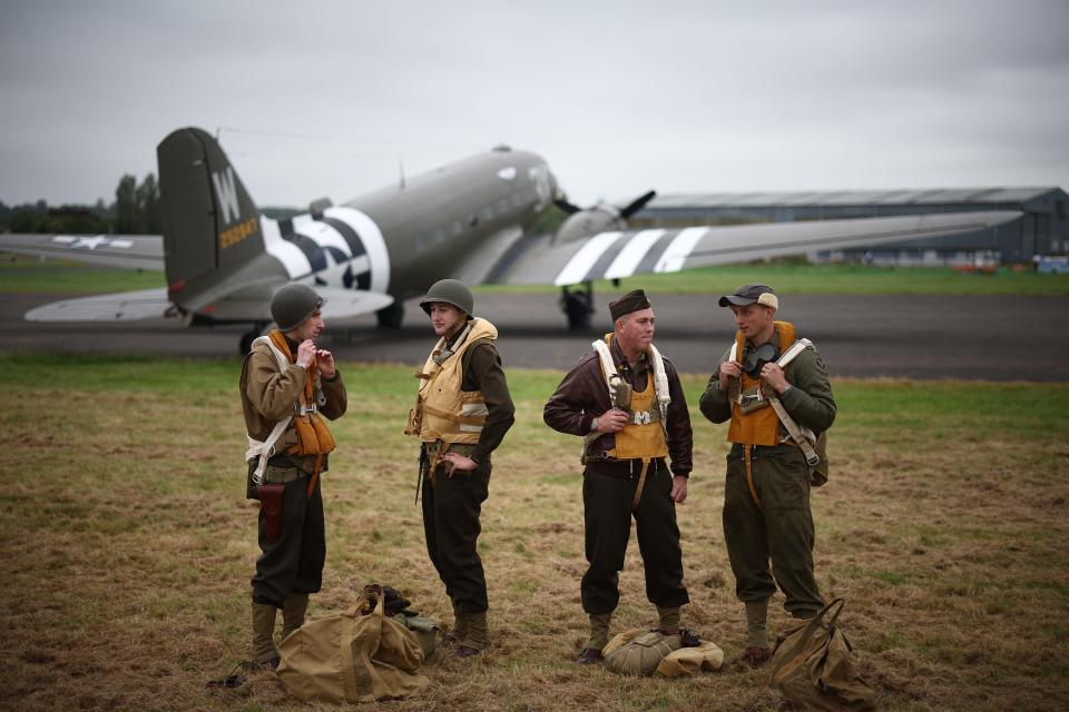 World War II reenactors pose on May 31 for a photograph beside a C-47 — an aircraft that carried paratroopers over the drop zones in Normandy, France — at North Weald Airfield in Epping, east of London ahead of the celebrations to mark the 80th anniversary of the D-Day landings.