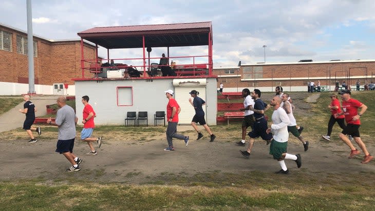 inmates run around a prison yard in a club