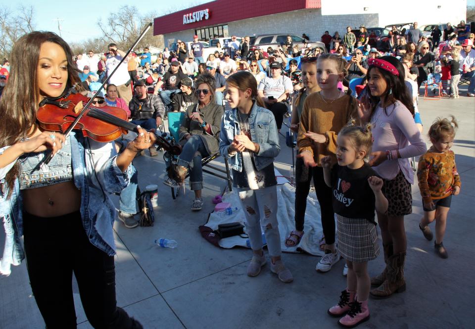 Fiddle player Melissa Barrison jumped from the stage into the crowd to play and dance with young fans outside the new Allsup's store in Tuscola.