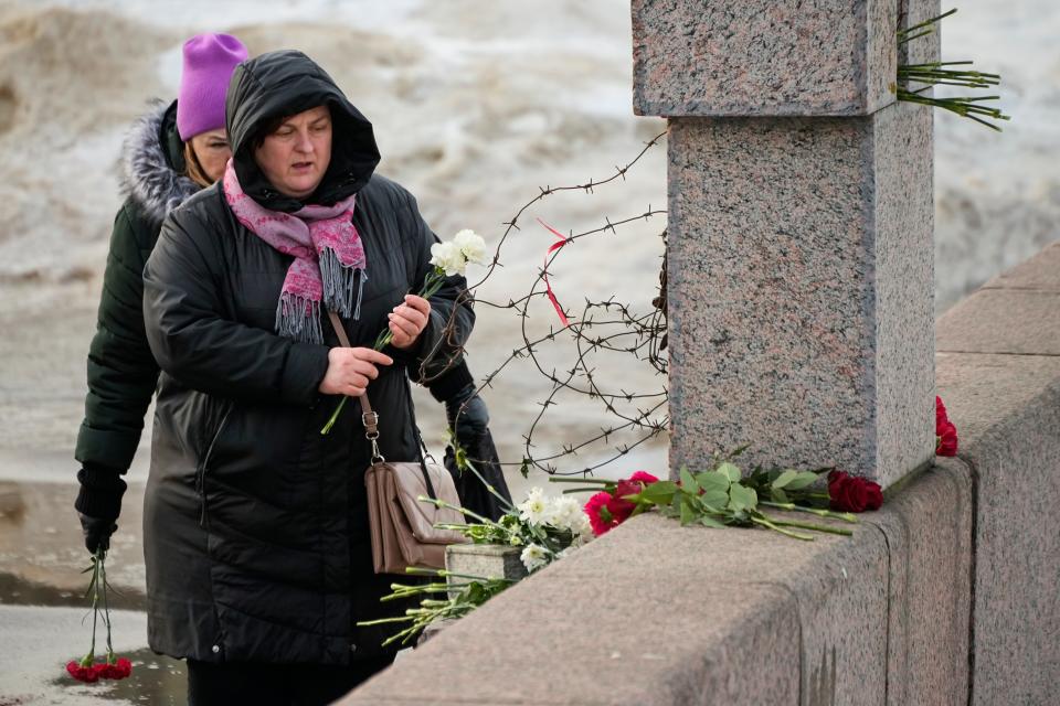 Women lay flowers at the Memorial to Victims of Political Repression to pay respect to Alexei Navalny in St Petersburg, Russia, Tuesday, 20 February 2024 (AP)