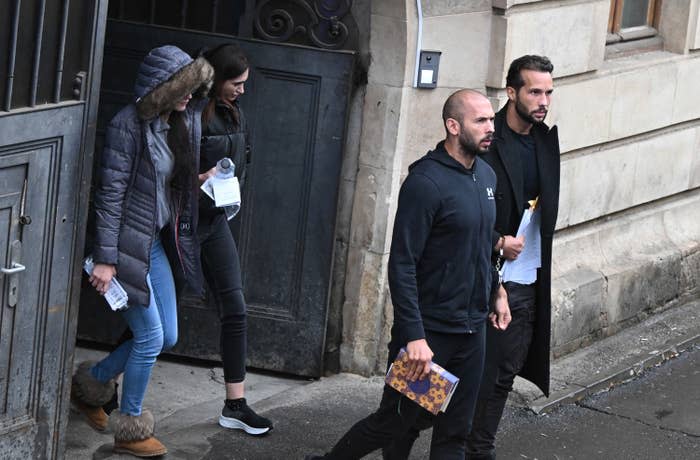 Former professional kickboxer and controversial influencer Andrew Tate (second from right), Tristan Tate (right), and two Romanian women (left) exit a court in Bucharest, Romania, on Jan. 10, 2023. 