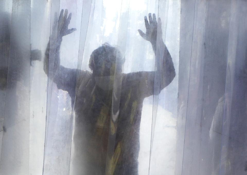 A man gets sanitized in a cabin while leaving a slum in Mumbai, India, Saturday, April 25, 2020. A tentative easing around the world of coronavirus lockdowns gathered pace Saturday with the reopening in India of neighborhood stores that many of the country’s 1.3 billion people rely on for everything from cold drinks to mobile phone data cards. (AP Photo/Rajanish Kakade)