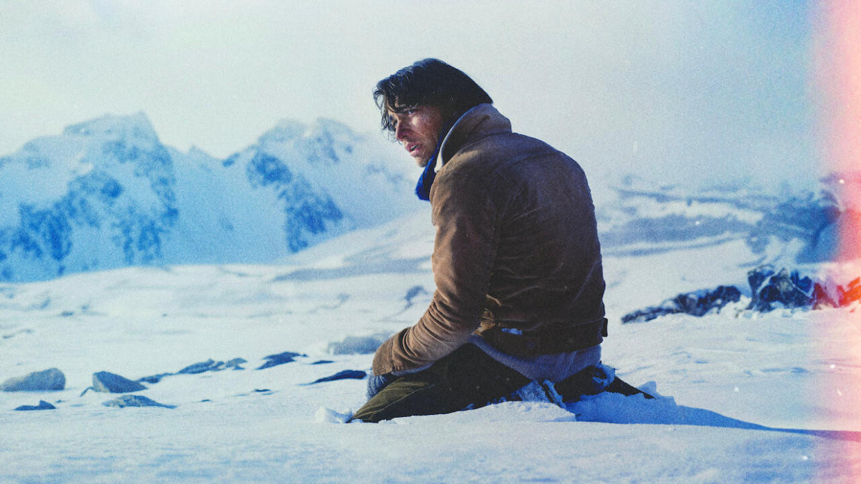  A man looks forlorn in the snow in the Netflix movie Society of the Snow. 