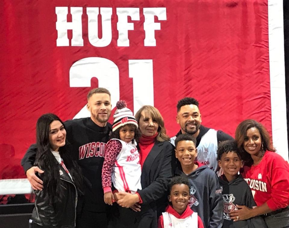 Theresa Huff holds her granddaughter and poses with her family during a halftime ceremony Sunday that included the raising of her jersey into the rafters of the Kohl Center on Jan. 29, 2023.