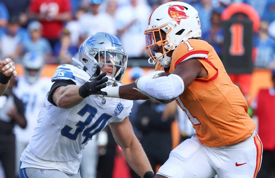 Buccaneers running back Rachaad White stiff-arms Lions linebacker Alex Anzalone during the first quarter of the Lions' 20-6 win on Sunday, Oct. 15, 2023, in Tampa, Florida.
