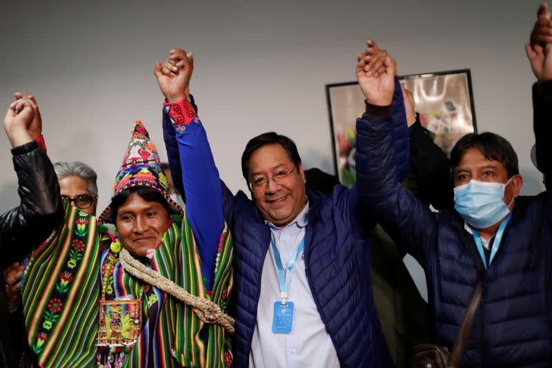 El candidato presidencial Luis Arce del partido Movimiento al Socialismo (MAS) reacciona junto al candidato a la vicepresidencia David Choquehuanca, que lleva una mascarilla, tras dirigirse a los medios de comunicación durante las elecciones presidenciales en La Paz, Bolivia.