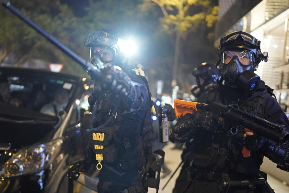 Riot police gestures to a crowd to clear the area during a rally on Christmas Eve in Hong Kong, Tuesday, Dec. 24, 2019. More than six months of protests have beset the city with frequent confrontations between protesters and police. (AP Photo/Kin Cheung)
