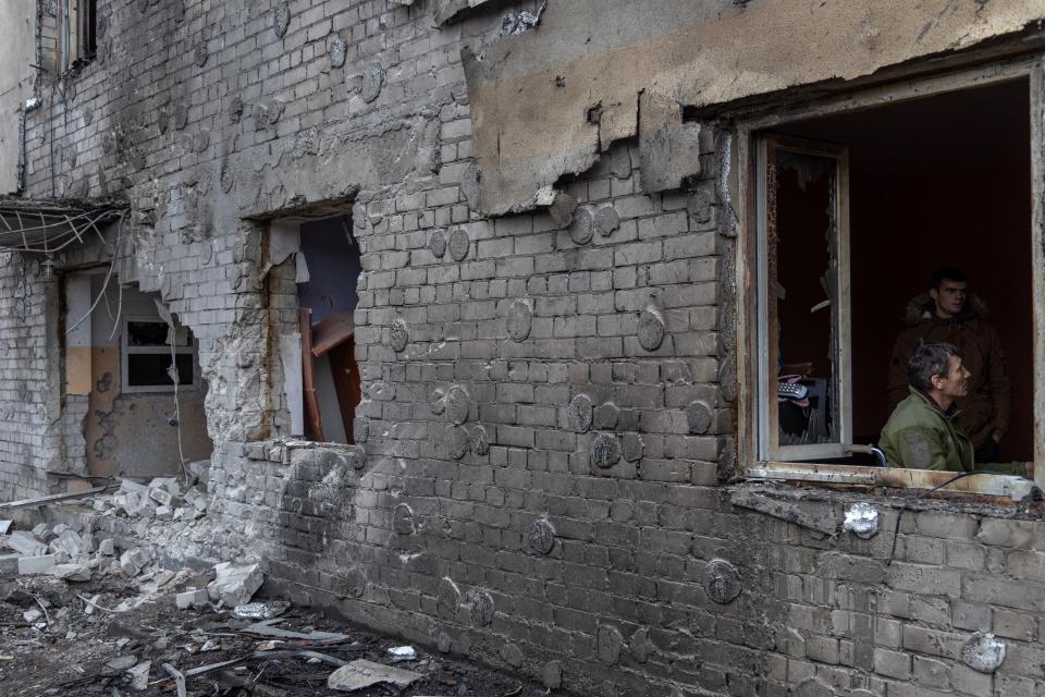 People inspect damage to the dormitory building after the falling of debris amid a drone attack in Odesa on December 14, 2023 (AFP via Getty Images)