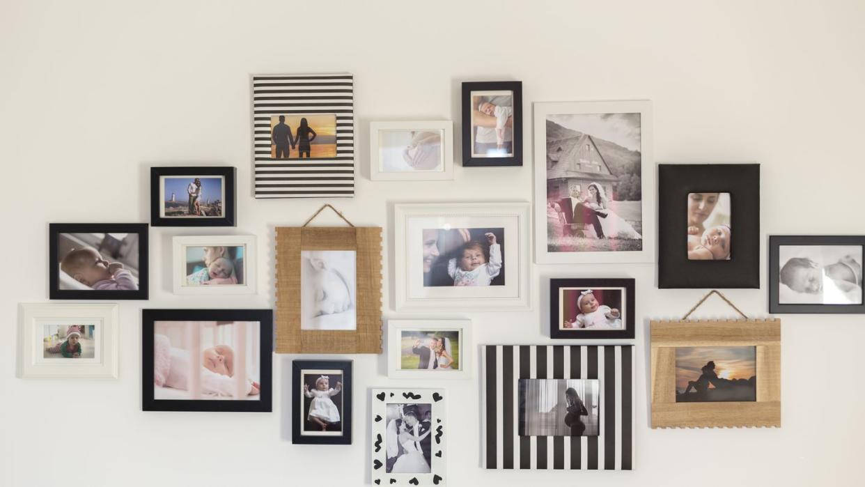 white wall with photos of the family in various photo frames