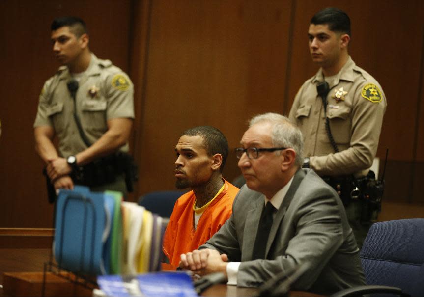 R&B singer Chris Brown, left, appears in Los Angeles Superior Court with his attorney Mark Geragos, on Monday, March 17, 2014. Brown will spend another month in jail after a judge said Monday he was told the singer made troubling comments in rehab about being good at using guns and knives. The singer was arrested on Friday, March 14, 2014, after he was dismissed from a Malibu facility where he was receiving treatment for anger management, substance abuse and issues related to bipolar disorder. (AP Photo/Lucy Nicholson, Pool)