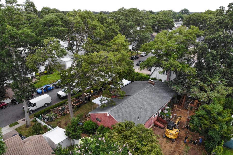 Authorities continue to work at the home of suspect Rex Heuermann, bottom right, in Massapequa Park, NY on Monday (AP)