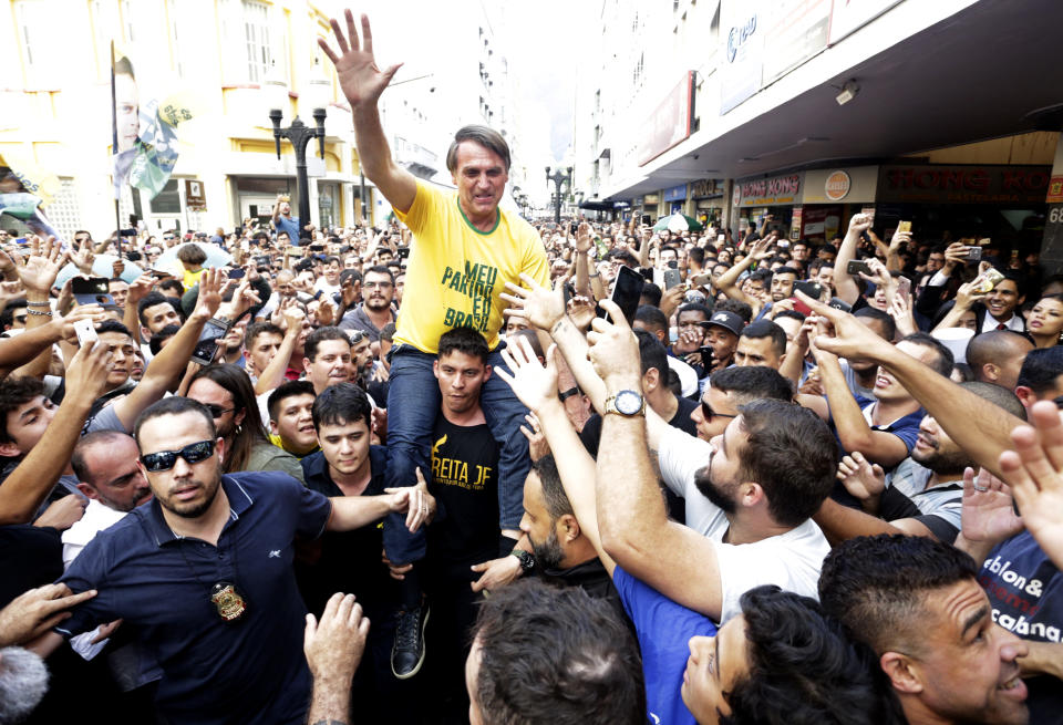FILE - In this Sept. 6, 2018 file photo, presidential candidate Jair Bolsonaro is taken on the shoulders of a supporter moments before being stabbed during a campaign rally in Juiz de Fora, Brazil. (Antonio Scorza/Agencia O Globo via AP File)