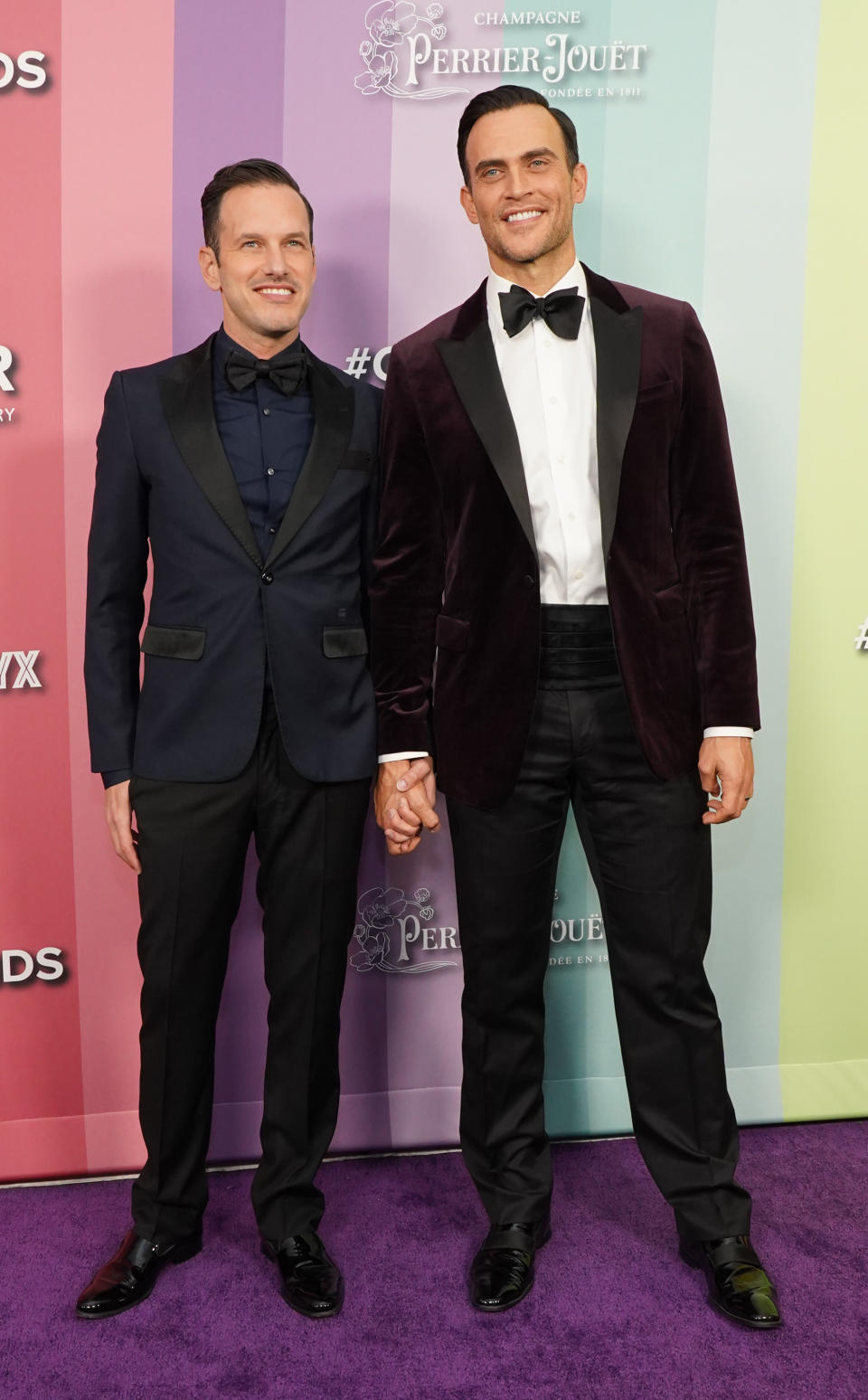 Jason Landau and Cheyenne Jackson hold hands at an event