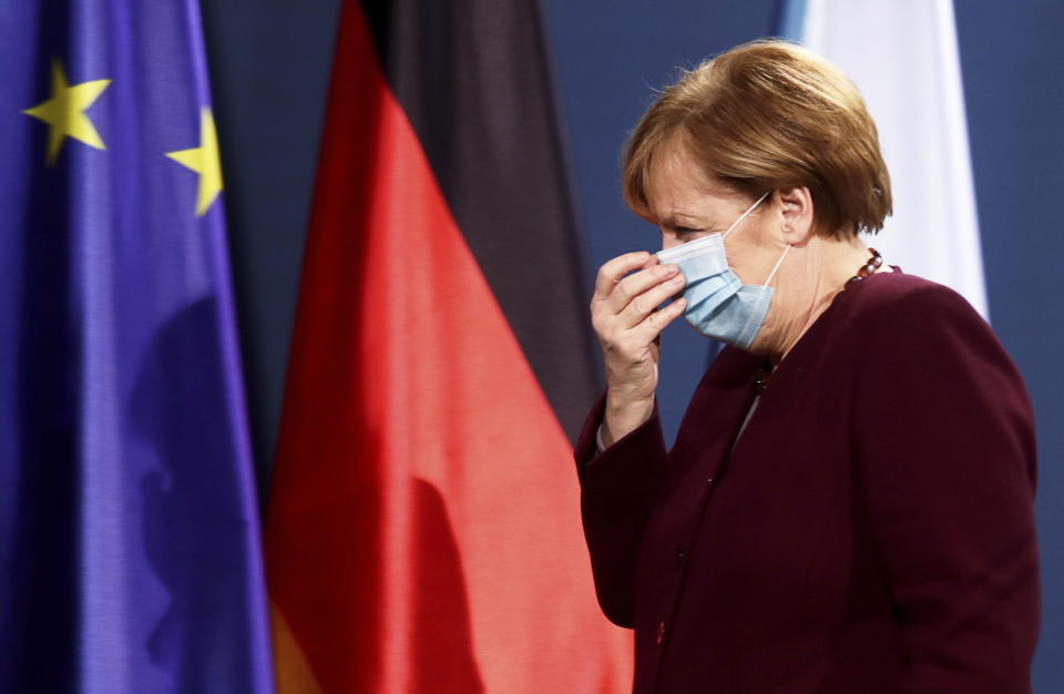 German Chancellor Angela Merkel leaves after holding a joint news conference with Finance Minister Olaf Scholz after a virtual G20 summit meeting, at the Chancellery in Berlin, Germany, Sunday Nov. 22, 2020. (Hannibal Hanschke/Pool via AP)