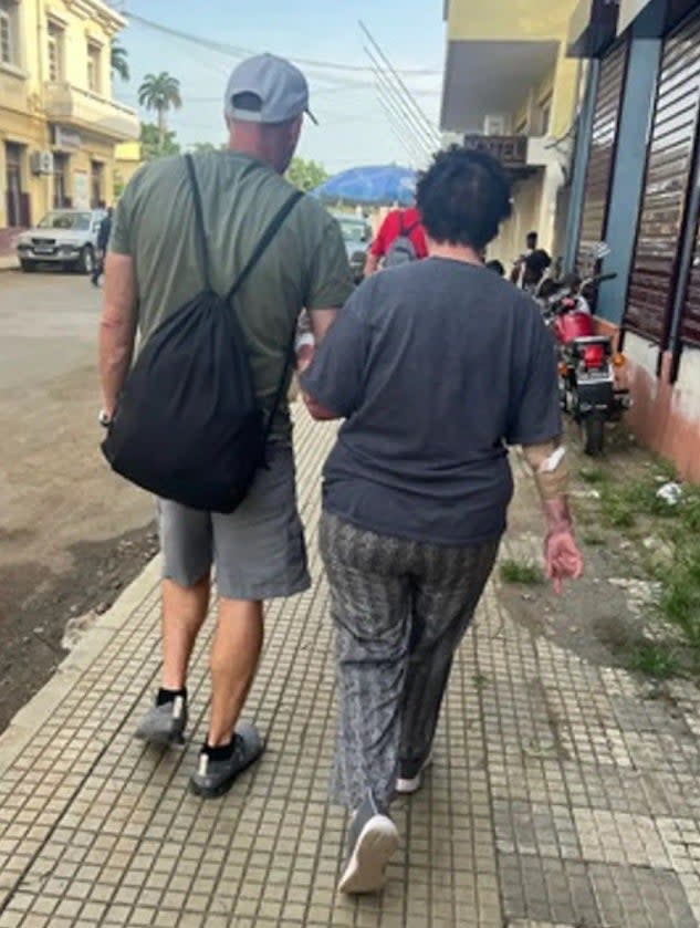 Julie Lenkoff being helped by Jay Campbell walk around the African island of São Tomé.