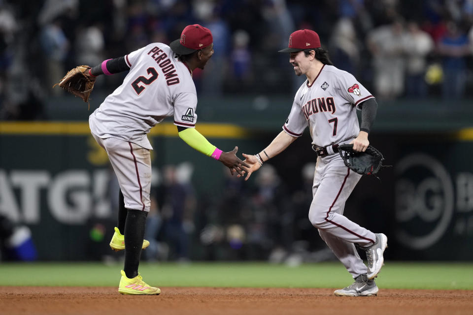 Arizona Diamondbacks' Geraldo Perdomo (2) and Corbin Carroll (7) celebrate after Game 2 of the baseball World Series against the Texas Rangers Saturday, Oct. 28, 2023, in Arlington, Texas. The Diamondbacks won 9-1. (AP Photo/Godofredo A. Vásquez)