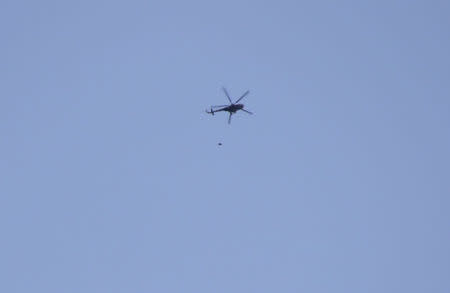 A helicopter loyal to Syrian President Bashar Al-Assad throws what activists say is an explosive barrel, in Al-Shaar area in Aleppo, February 1, 2014. REUTERS/Mohamed Mounzer Masri