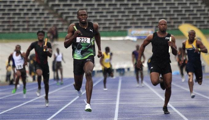 Jamaican runners Usain Bolt (232) of the Racers Track Club races ahead of Asafa Powell (2nd R) of the MVP Track Club in the men's 4x100m relay at the Utech Classic in Kingston April 14, 2012. Bolt finished first and Powell second. Picture taken April 14, 2012.