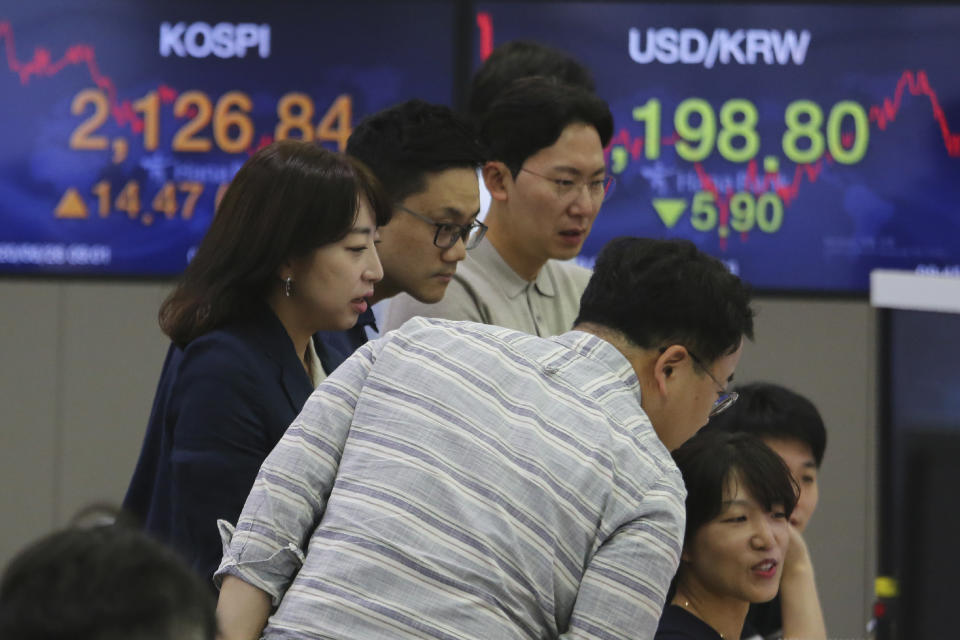 Currency traders watch monitors at the foreign exchange dealing room of the KEB Hana Bank headquarters in Seoul, South Korea, Friday, June 26, 2020. Asian stock markets followed Wall Street higher on Friday after U.S. regulators removed some limits on banks' ability to make investments. (AP Photo/Ahn Young-joon)