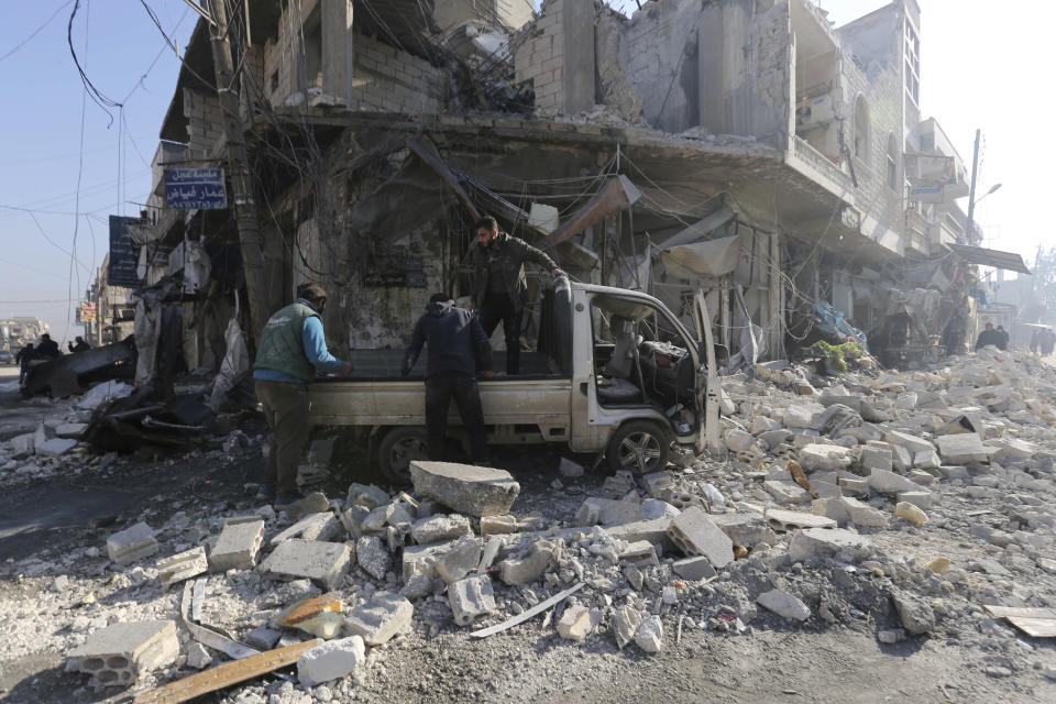 People gather in the the market in the city of Saraqeb in the Idlib countryside after an air strike by Syrian aircraft on Saturday, Dec. 21, 2019. Airstrikes on a rebel-held town killed several people and wounded more than a dozen in the northwestern province of Idlib, the last remaining rebel stronghold in the war-torn country, opposition activists said. The attack came amid a government offensive in the region. (AP Photo/ Ghaith al-Sayed)