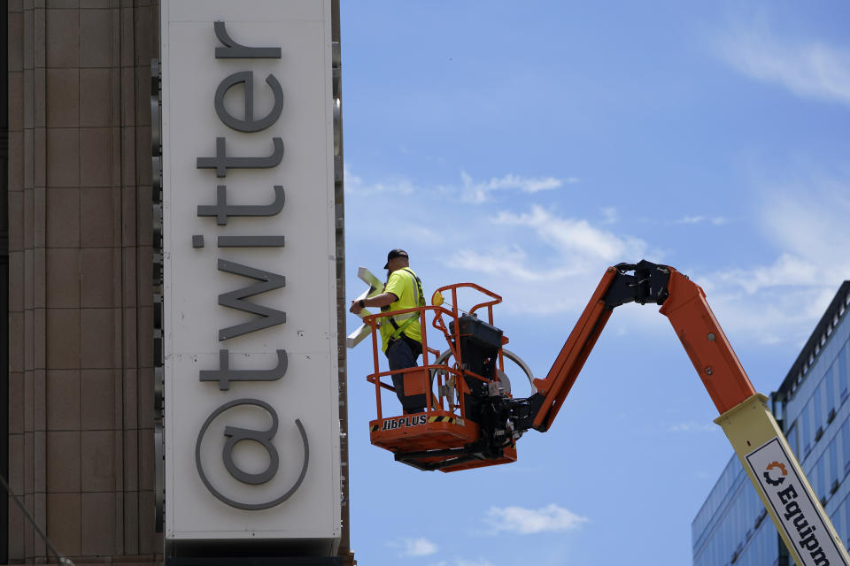 A workman removes a character from a sign on the Twitter headquarters building in San Francisco, Monday, July 24, 2023. Elon Musk has unveiled a new "X" logo to replace Twitter's famous blue bird as he follows through with a major rebranding of the social media platform he bought for $44 billion last year. The X started appearing at the top of the desktop version of Twitter on Monday, but the bird was still dominant across the smartphone app. (AP Photo/Godofredo A. Vásquez)