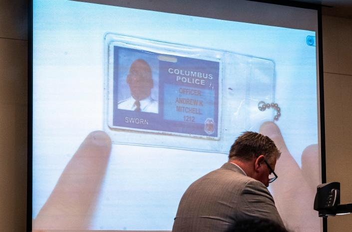 Defense attorney Mark Collins shows on the projection screen to a Franklin County Common Pleas Court jury the plastic ID badge that former Columbus police vice officer Andrew Mitchell testified he showed 23-year-old Donna Castleberry to help prove he was a police officer because he did not have his official badge on the day he fatally shot Castleberry in an unmarked car.