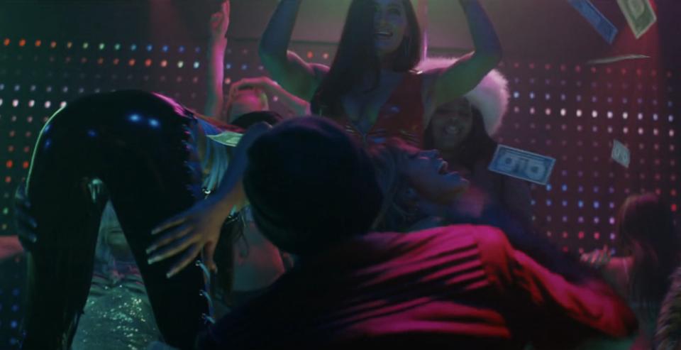 Usher throwing money on stage to performers in "Hustlers"