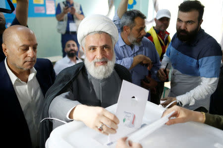 Lebanon's Hezbollah deputy leader Sheikh Naim Qassem casts his vote as he stands next to Hezbollah parliament candidate Amin Sherri at a polling station during the parliamentary election, in Beirut, Lebanon, May 6, 2018. REUTERS/Mohamed Azakir