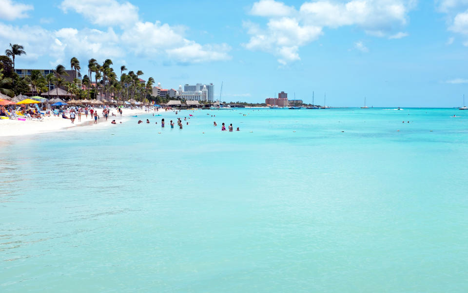 <p><strong>Why Go:</strong> Besides a two-mile strip of high-rise luxury hotels, Aruba’s Palm Beach has the benefit of proximity to the warm inviting waters of the southern Caribbean. The climate is dry, so it’s unusual for any outdoor plans to be ruined by rain.</p> <p><strong>What to Do: </strong>While the shoreline is by far Palm Beach’s main draw, it’s common for visitors to rent a car and drive into town for meals and the occasional indoor activity, like glow bowling or shopping.</p> <p><strong>Where to Stay:</strong> Amenities at <a rel="nofollow noopener" href="http://www.marriott.com/hotels/travel/auaac-marriotts-aruba-surf-club/" target="_blank" data-ylk="slk:Marriott’s Aruba Surf Club;elm:context_link;itc:0;sec:content-canvas" class="link ">Marriott’s Aruba Surf Club</a> include a lazy river, a kids’ waterslide, and tennis and volleyball courts. Adorable (and harmless) iguanas crawl around and each morning and at 10 a.m. guests can feed them. </p>