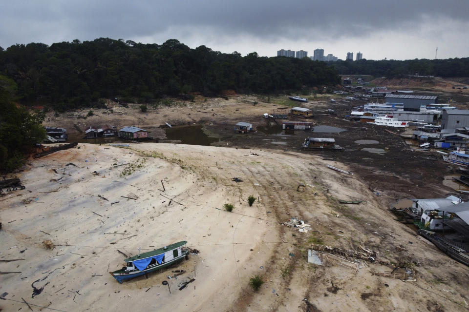 Boats are stuck in a dry area of the Negro River during a drought in Manaus, Amazonas state, Brazil, Monday, Oct. 16, 2023. The Amazon’s second largest tributary on Monday reached its lowest level since official measurements began near Manaus more than 120 years ago. (AP Photo/Edmar Barros)