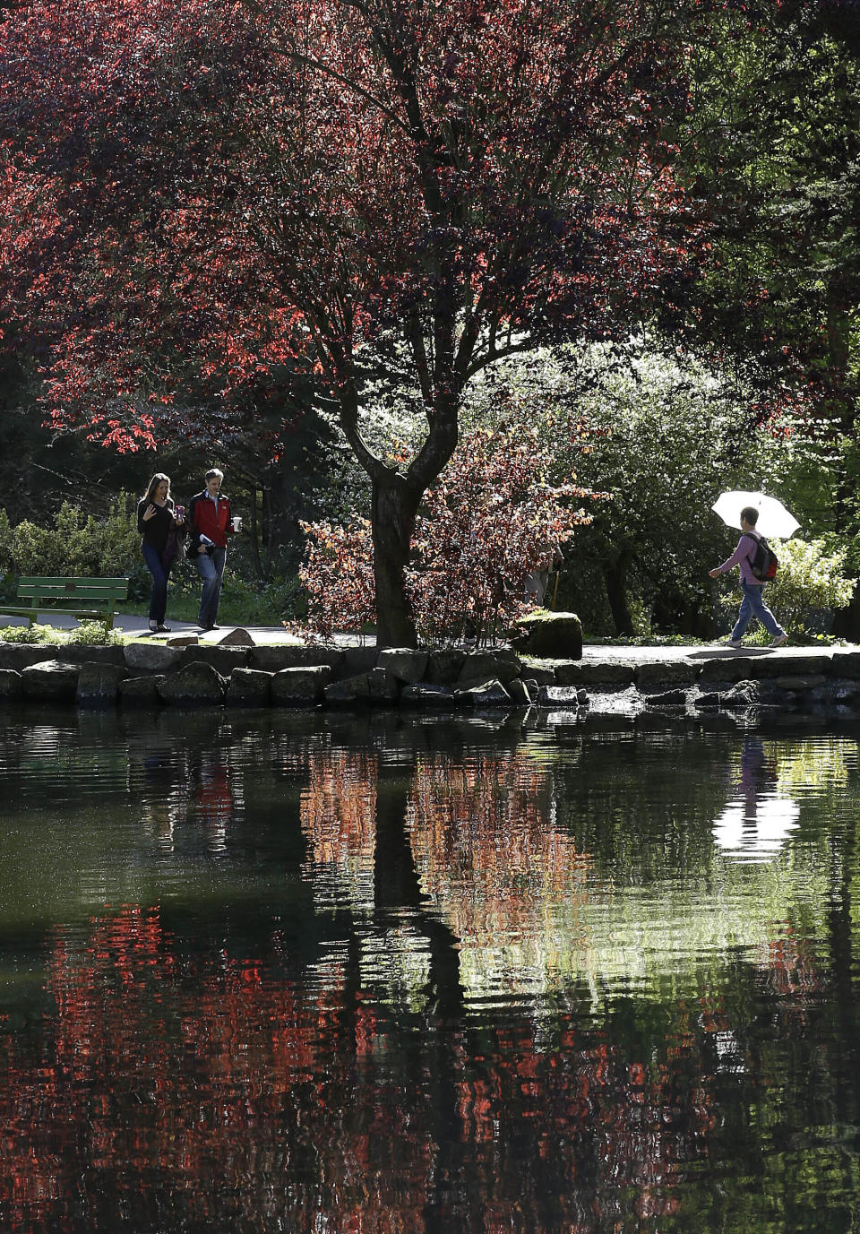 FILE - In this March 10, 2014, file photo, pedestrians walk along a path at Golden Gate Park's Stowe Lake in San Francisco. Golden Gate Park turned 150 years old on Saturday, April 4, 2020, and the huge party to celebrate San Francisco's beloved treasure will, for the time being, take place online. (AP Photo/Jeff Chiu, File)