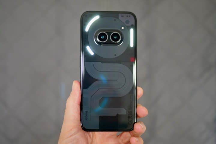 A person holding the Nothing Phone 2a, showing the Glyph Lights.