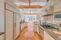 <p>The long and narrow kitchen has all amenities you could need, including modern appliances and granite counters. It also has a vaulted ceiling. <br> (Realtor.com) </p>