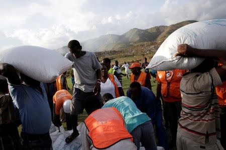 Haitians load supplies delivered by a Marines helicopter after Hurricane Matthew in Les Anglais, Haiti, October 11, 2016. REUTERS/Andres Martinez Casares