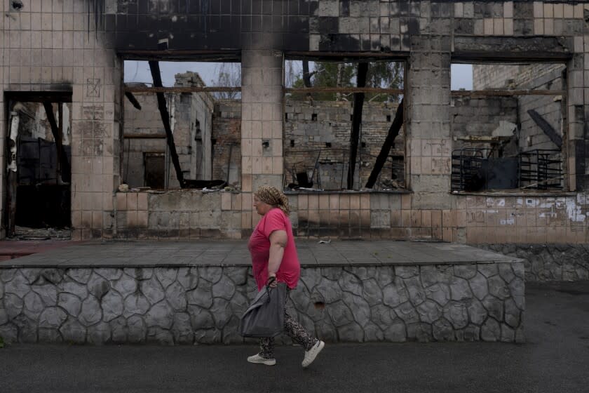 A woman heads to the market in Makariv, on the outskirts of Kyiv, Ukraine, Tuesday, June 14, 2022. (AP Photo/Natacha Pisarenko)