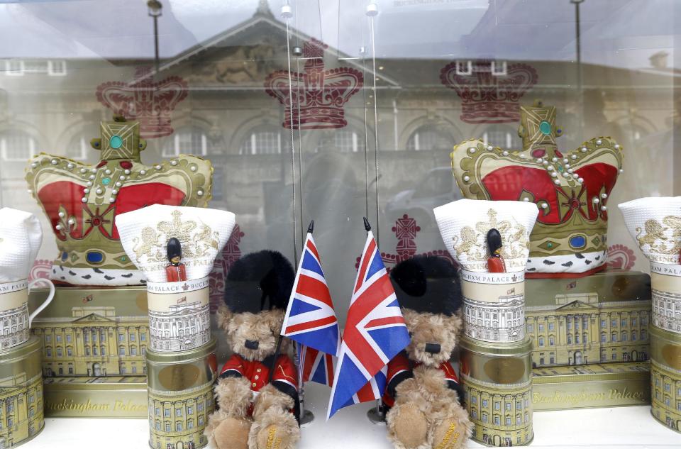 Buckingham Palace is reflected in the window of a souvenir shop selling teddy bears in London, Wednesday, July 24, 2013. Sales of royal related souvenirs are expected to rise after Britain's Duchess of Cambridge gave birth to a baby boy who will be third in line to the throne. (AP Photo/Kirsty Wigglesworth)