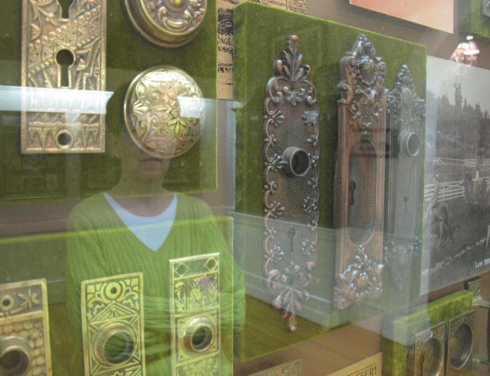 In this photo, taken Saturday, Feb. 25, 2012, at the Green Park Inn in Blowing Rock, N.C., a guest's face is reflected in a case displaying old hardware from the hotel's restoration. The property started as a boarding house in 1882. (AP Photo/Allen Breed)