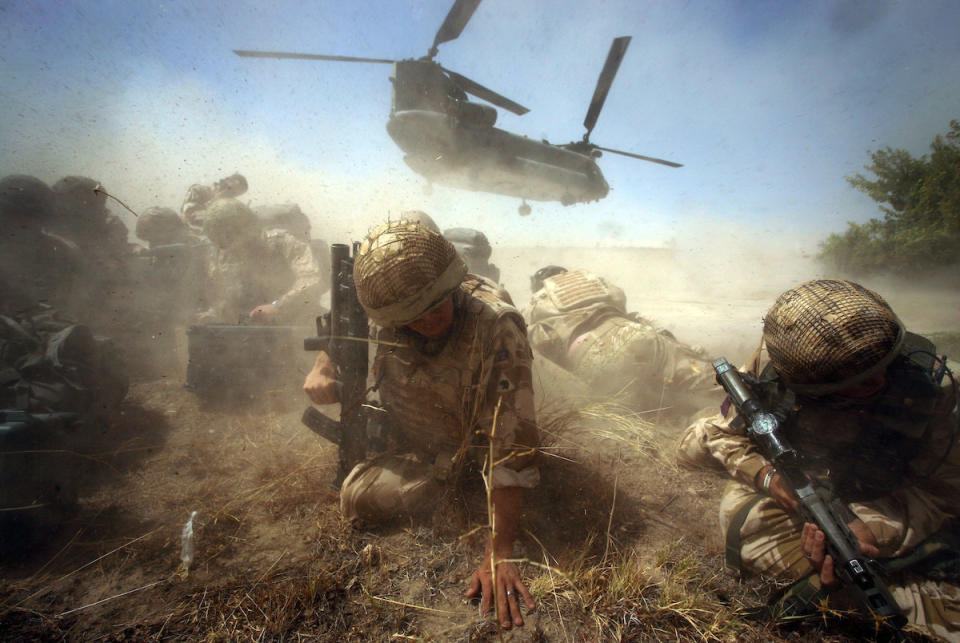 British army troops shelter from the dust storm as their chinook helicopter departs from Cher-E-Anjir town in Helmand Province, Afghanstan, August 12th 2009. A local building in the area has been taken over by the British armed forces Prince of Wales's Company as an outpost of the Welsh Guards regiment in Nad-E-Ali.